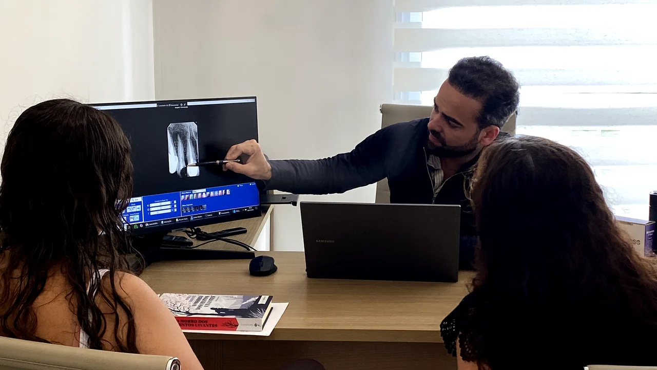 Dr. Fábio explicando o diagnóstico na tela para pacientes durante a avaliação